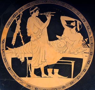 Symposion-scene med aulos-spiller og en liggende mand som holder en drikkekop. fra Athen, c. 450 f.Kr.(Staatliche Antikensammlungen)