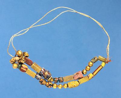 Guld fra akan-folket. Halssmykke med perler og bjælder af guld. Udstillet i Etnografisk Samling