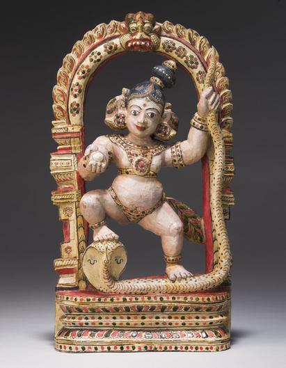 Træfigur forestillende guden Krishna, som danser på slangen Kaliya. Indsamlet af Konrad Emile Mourier, som var dansk guvernør fra 1832-1838. Foto: Arnold Mikkelsen, 2005. Nationalmuseet (Inv.nr. Da.127)