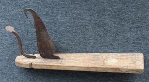 Opretstående kniv, som bruges på gulvet og holdes fast med foden. Det yderste redskab til venstre bruges til at raspe frugtkødet af tørrede kokosnødder.