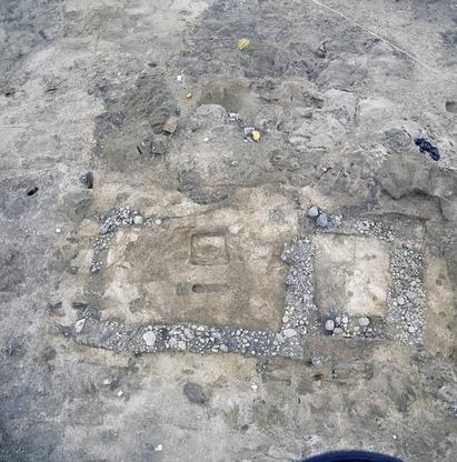 Udgravning af kirketomten i Tirup set lidt fra oven. Kirkens stenfundament viser tydeligt kirkens grundrids. Inde i skibet og neden for koret ses grave åbnet af arkæologerne.