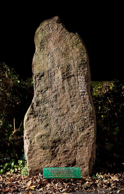Foto af høj runesten i naturen.