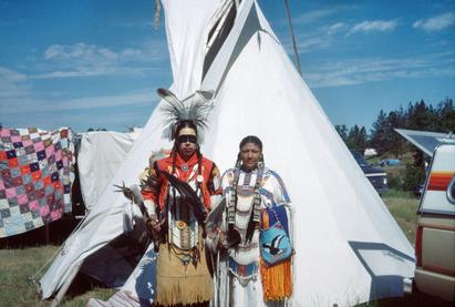 Indiansk par i dragter, foran telt