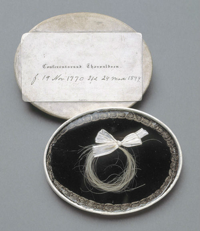 Lok af Bertel Thorvaldsens hår i æske. Hårlokken har tilhørt kammerassessor C.F. Wilckens. Senere kom den i forfatteren Johannes V. Jensens eje.